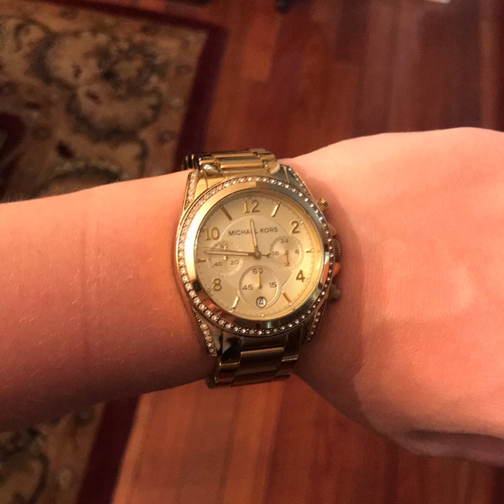 Michael Kors Gold Tone with rhinestone bezel.